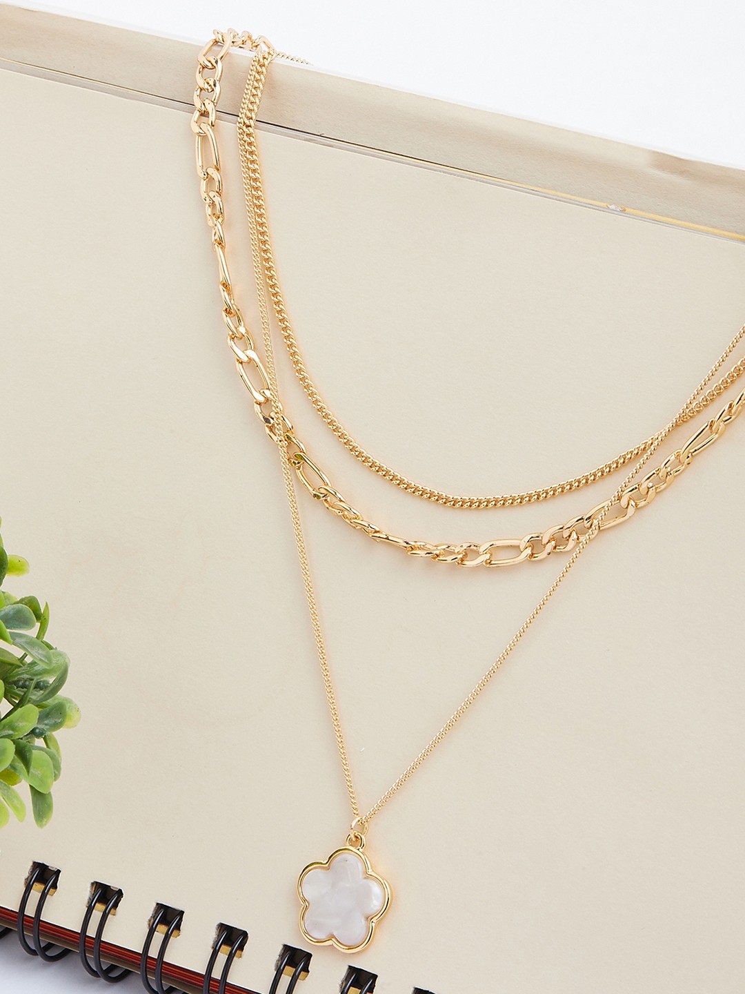 Gold toned three layered necklace with white flower pendant