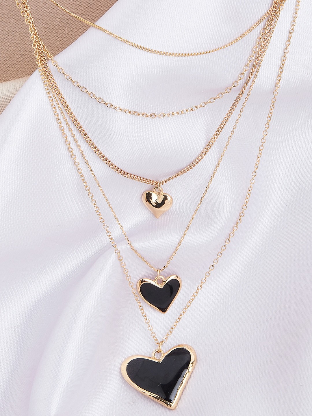 Gold toned five layered necklace with black enameled heart pendant
