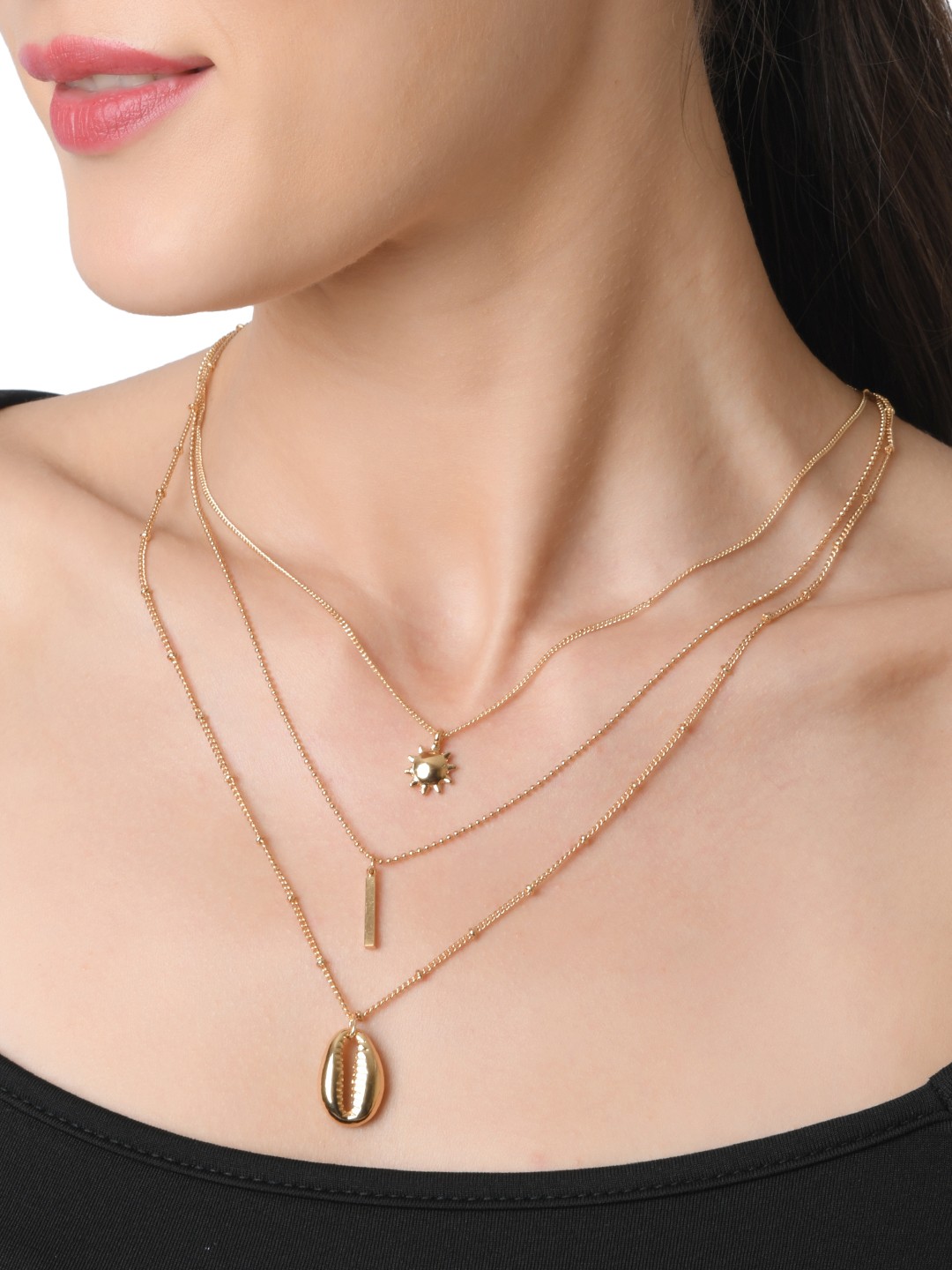 Gold toned three layered necklace with bar, shell and sun charm