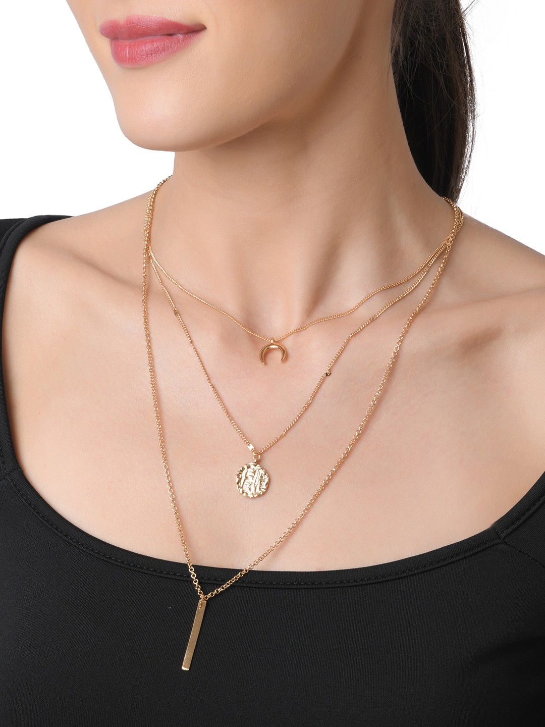 Gold toned four layered necklace with moon, textured coin and bar charm