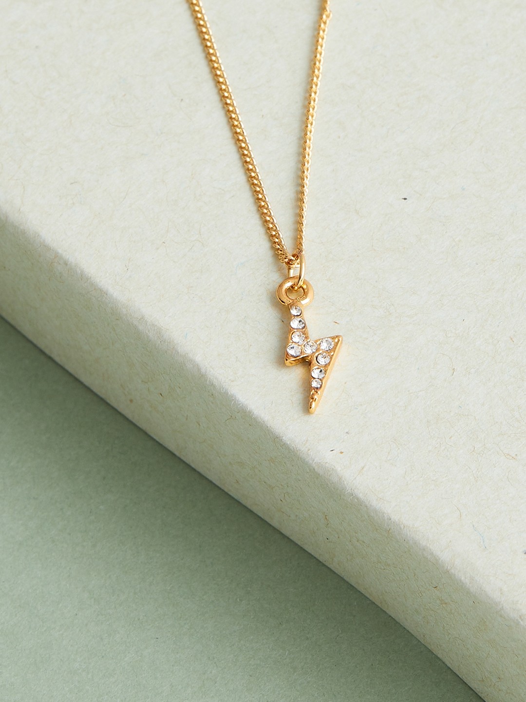 Gold toned chain with crystal studded thunder pendant