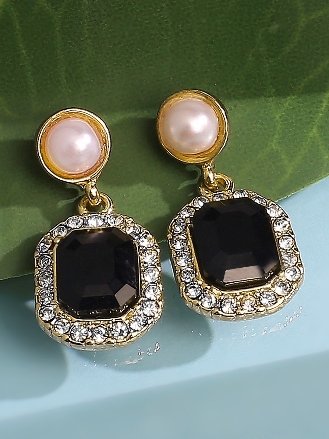 Gold toned dangler earrings with black stone