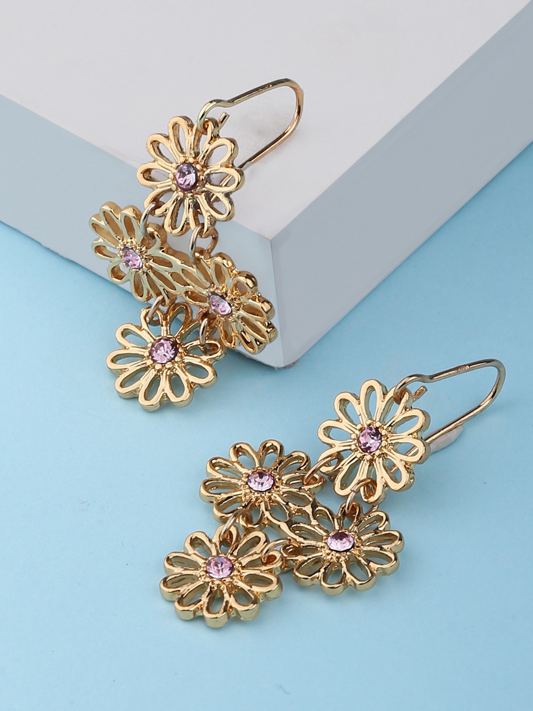 Gold toned dangler earrings with flower and pink stone