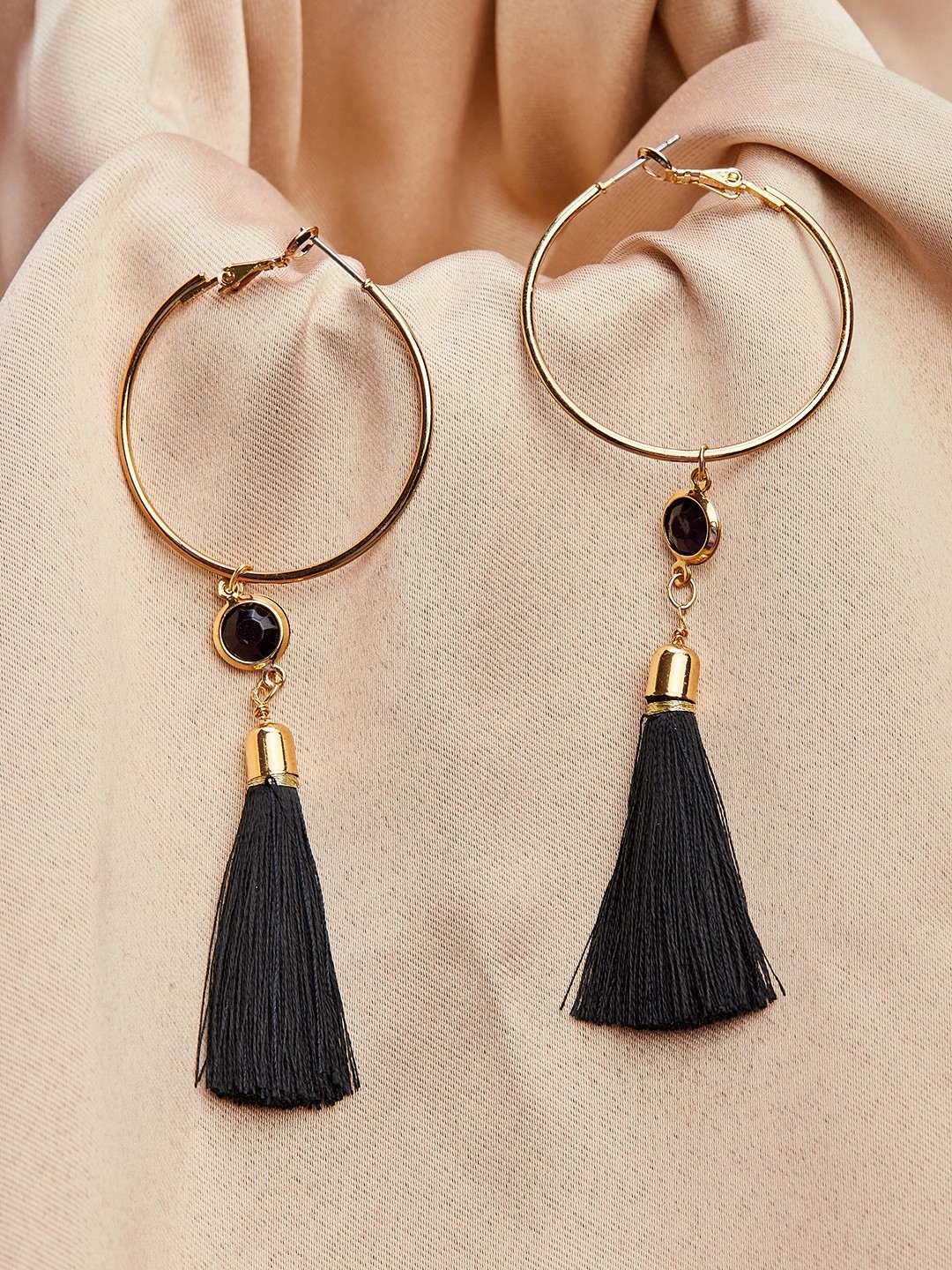 Gold toned black tassel hoop earrings with black stone